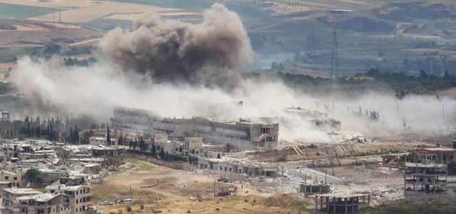الدخان يتصاعد من المستشفى الوطني في جسر الشغور بريف إدلب بعد غارات لطائرات النظام لفك الطوق عن المتحصنين بداخله.  رويترز