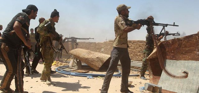 عناصر من «الحشد الشعبي» يطلقون النار على «داعش» في محيط مصفاة بيجي شمال تكريت. أ.ف.ب