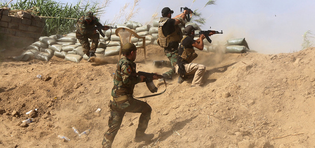 مقاتلون من أبناء العشائر يطلقون النار باتجاه تنظيم «داعش» على مشارف مصفاة بيجي. أ.ف.ب