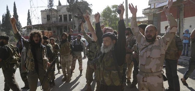 مقاتلون من «جيش الفتح» يحتفلون وسط مدينة أريحا بسيطرتهم على المدينة الأكبر للنظام في ريف إدلب. رويترز