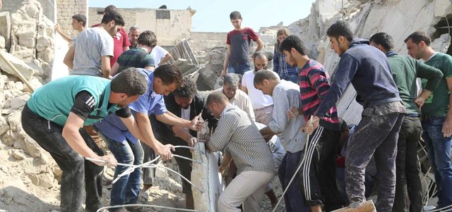سكان وأفراد الدفاع المدني يبحثون عن ناجين تحت أنقاض مبنى تهدم ببرميل متفجر ألقته القوات النظامية على حلب القديمة. رويترز