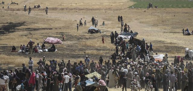 لاجئون سوريون يتجمعون عند نقطة حدودية مع تركيا. أ.ف.ب