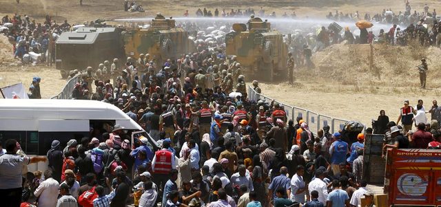 الجيش التركي يستخدم مدافع المياه لوقف اندفاع اللاجئين السوريين نحو السياج الحدودي. رويترز