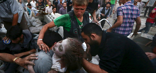 مدنيون يُخرجون فتاة من تحت أنقاض منزل تهدم بقصف للقوات النظامية على مدينة دوما بريف دمشق. رويترز