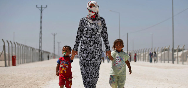 لاجئة تتجول في مخيم للاجئين ببلدة سورس التركية على الحدود مع سورية. أ.ب