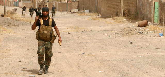 مقاتلون من «الحشد الشعبي» يرافقون القوات الحكومية في مدينة بيجي. أ.ب