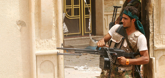 مقاتلان من «الحشد الشعبي» خلال عملية في مدينة بيجي. أ.ب