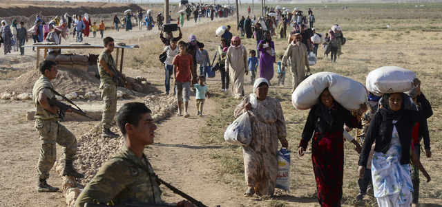 صورة أرشيفية لأكراد سوريين يفرون إلى تركيا هرباً من المعارك.  أ.ف.ب