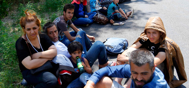 لاجئون سوريون يستريحون بعد عبور الحدود بشكل غير قانوني من صربيا إلى المجر. رويترز