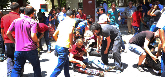 شبان يساعدون الجرحى الذين أصيبوا بالتفجير الانتحاري في حديقة مركز ثقافي في سروج. أ.ب