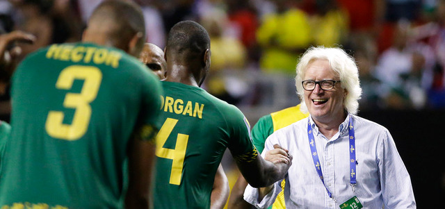 لاعبو جامايكا يتلقون تهنئة المدير الفني شايفر بعد الفوز على المنتخب الأميركي والتأهل للمباراة النهائية. أ.ب