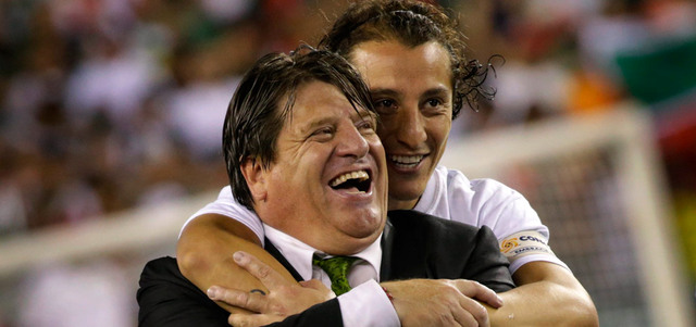 مدرب المكسيك هيريرا ونجمه غواردادو في قمة السعادة بعد الفوز باللقب.    أ.ف.ب