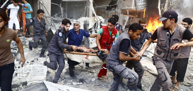 مسعفون يحملون رجلاً أصيب بغارة للقوات النظامية على دوما بريف دمشق. أ.ف.ب