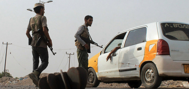 مقاتلان من المقاومة الشعبية عند نقطة تفتيش في ضاحية دار سعد شمال عدن.  أ.ف.ب