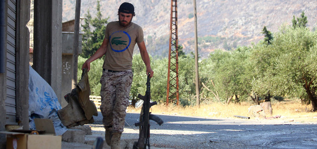 مقاتل من «جيش الفتح» يحمل سلاحه في بلدة الصفصافة بعد اشتباكات مع القوات النظامية  في ريف حماة. رويترز