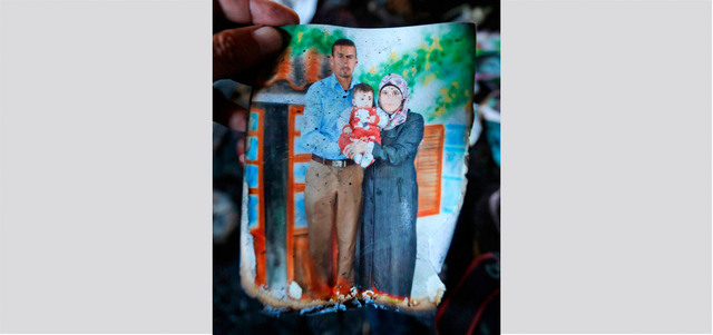 صورة للرضيع علي دوابشة مع ذويه وجدت في منزلهم المحروق. إي.بي.إيه