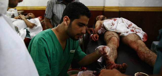 مسعفون يقدّمون العلاج الأولي في مستشفى ميداني لأحد المصابين في غارة للقوات النظامية على مدينة دوما بريف دمشق. أ.ف.ب