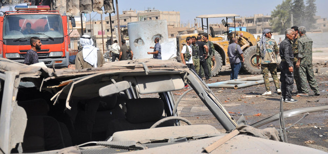 أكراد يتفقدون الأضرار الناجمة عن التفجير الانتحاري الذي استهدف مقر قيادة قوات الأمن الكردية (الآسايش) في المنطقة الصناعية بمدينة القامشلي. أ.ف.ب