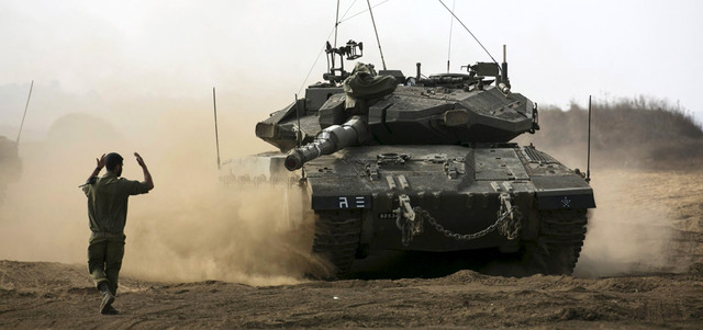جندي إسرائيلي يوجه دبابة، خلال تدريب في مرتفعات الجولان المحتلة، بالقرب من خط وقف إطلاق النار مع سورية.  رويترز
