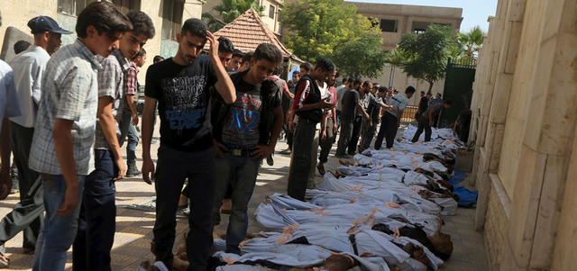 مدنيون يحاولون التعرف إلى جثث القتلى الذين سقطوا بغارة للقوات النظامية على سوق شعبية في مدينة دوما.  رويترز