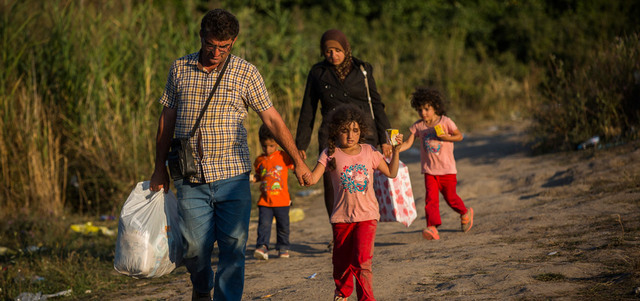 لاجئون سوريون يعبرون الحدود من مقدونيا إلى صربيا سيراً على الأقدام. أ.ب