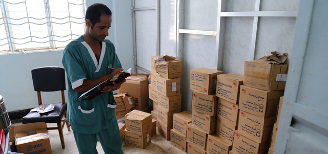 موظف صحي يتحقق من صناديق من اللوازم الطبية في مستشفى بجنوب غرب مدينة تعز أمس. أ.ف.ب