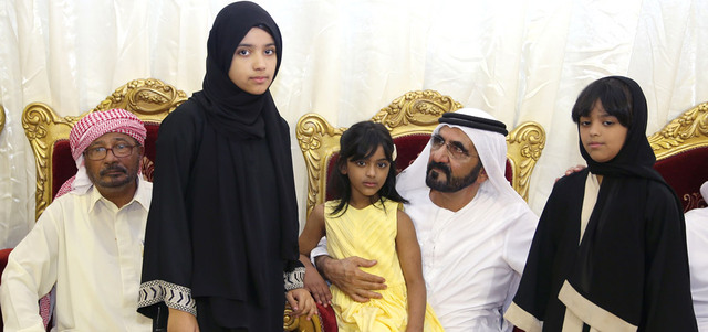 محمد بن راشد محتضناً أطفال الشهيد عبدالله عمر مبارك الجابري. وام