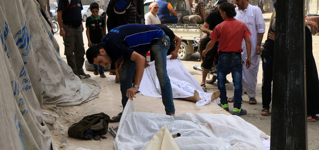 سوريون يلقون نظرة على جثث ضحايا قتلوا بقصف على حي الشعار في مدينة حلب. أ.ف.ب