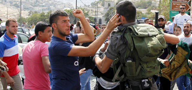 شرطي إسرائيلي يتلقى لكمة من فلسطيني خلال مواجهات الأقصى. أ.ف.ب