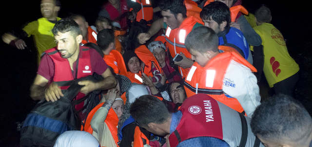 لاجئون سوريون لدى وصولهم على زورق مكتظ إلى جزيرة ليسبوس اليونانية وسط أمواج عاتية.   رويترز