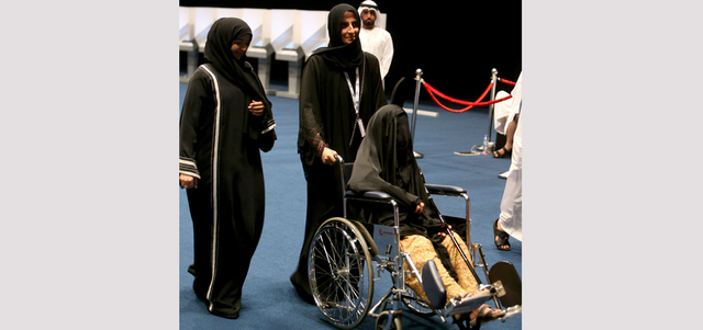 متطوعة تساعد امرأة مسنّة على كرسي متحرك للإدلاء بصوتها. تصوير: نجيب محمد