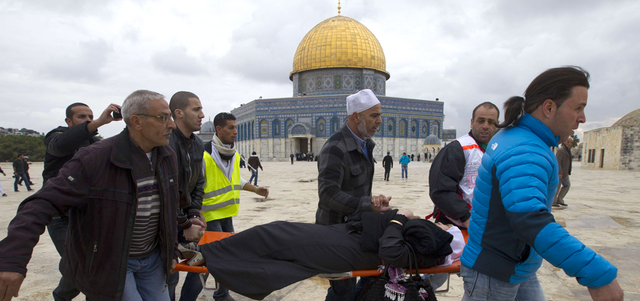مسعفون يحملون امرأة مصابة خلال الصراع في القدس. أ.ف.ب