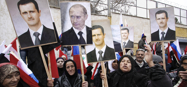 مؤيدون لنظام الأسد يرفعون صوره وصورة بوتين.  أرشيفية