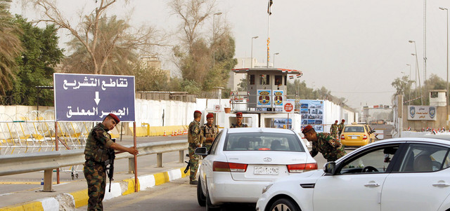 عناصر أمن ينظمون دخول السيارات إلى المنطقة الخضراء في بغداد.  رويترز