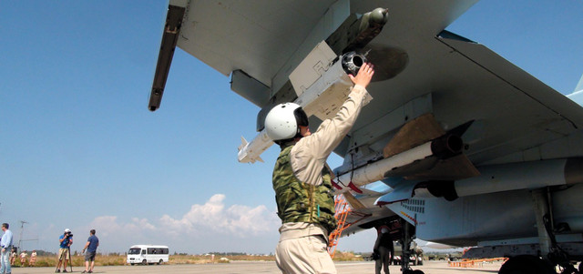 طيار روسي يهيأ صاروخاً جو-جو في مقاتلة «سوخوي30» بقاعدة مطار حميميم الجوية في سورية. أ.ب
