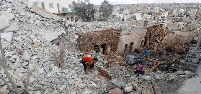 مدنيون يتفقدون منازل تهدمت بغارات روسية على بلدة دارة عزة بريف حلب. رويترز