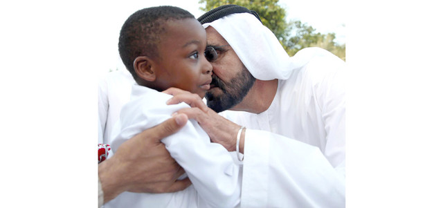 محمد بن راشد يطبع قبلة أبوية على وجنة نجل الشهيد البطل أحمد مال الله الحمادي. وام