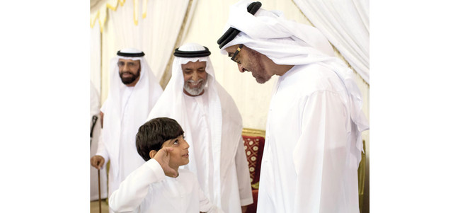 محمد بن زايد يتلقى تحية ولاء من نجل الشهيد البطل علي الكتبي.وام