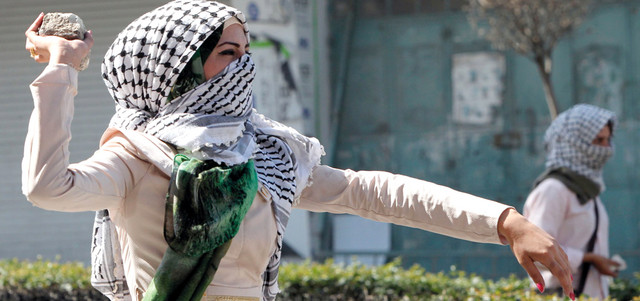 طالبة من جامعة الخليل خلال المواجهات مع قوات الاحتلال في المدينة. أ.ف.ب
