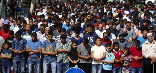 فلسطينيون يؤدون صلاة الجمعة خارج المسجد الأقصى بعد منعهم من الدخول إلى القدس.  أ.ف.ب