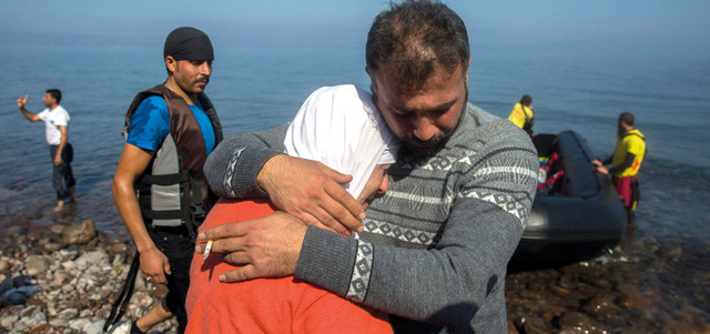 لاجئ سوري يعانق زوجته لدى وصولهما على زورق صغير إلى جزيرة ليسبوس اليونانية. أ.ب