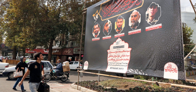 إيراني يمر أمام لافتة في طهران تظهر صوراً لقياديين في الحرس الثوري قتلوا في سورية. أ.ف.ب