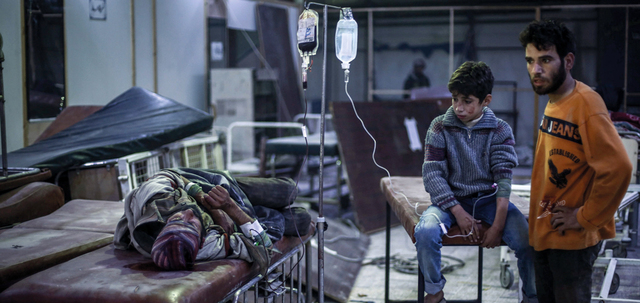 سوري يتلقى الإسعافات الأولية في مستشفى ميداني بعد إصابته بغارة للقوات النظامية على دوما.  إي.بي.إيه
