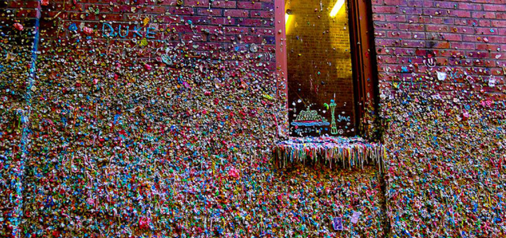 والحائط المغطى بالعلكة هو جزء من شباك التذاكر لمبنى المسرح المتواجد في السوق.