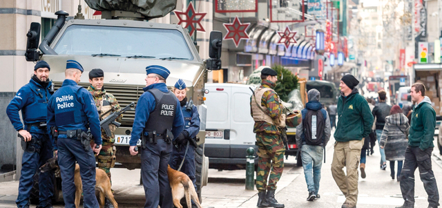 رجال الشرطة والجيش البلجيكيان يراقبون حركة الناس في شارع تسوق رئيسي. أ.ب