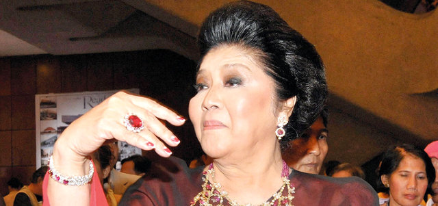 إيميلدا ماركوس تعرض إحدى قطع مجوهراتها.