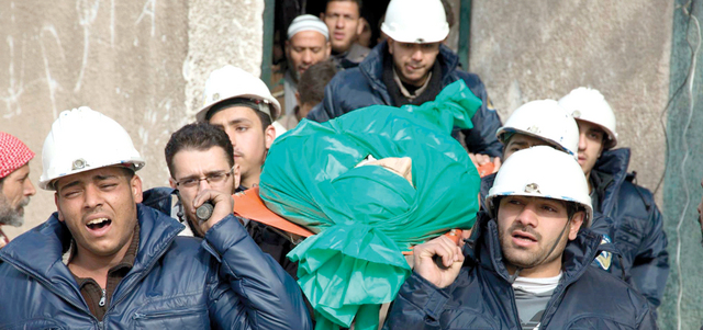 عناصر من الدفاع المدني يشيعون زميلاً لهم قتل بقصف للنظام على مدينة دوما بريف دمشق. أ.ب