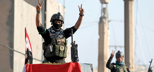 عنصر من قوات النخبة في جهاز مكافحة الإرهاب العراقي يرفع شارة النصر بعد طرد &laquo;داعش&raquo; من مدينة الرمادي.  أ.ف.ب