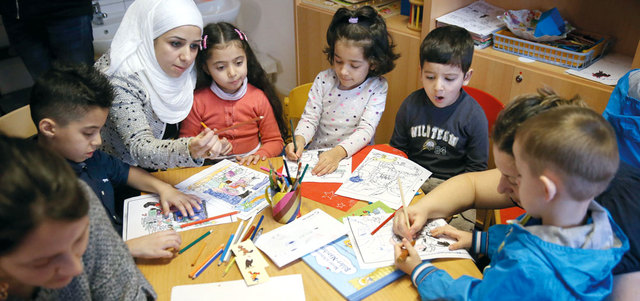 أطفال اللاجئين مع أمهاتهم خلال جلسة تعليم ولعب. غيتي