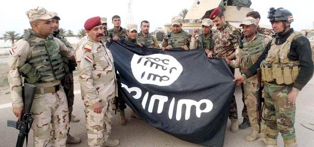 عناصر من قوات الأمن العراقية ينزعون راية «داعش» من مدينة الرمادي.   رويترز
